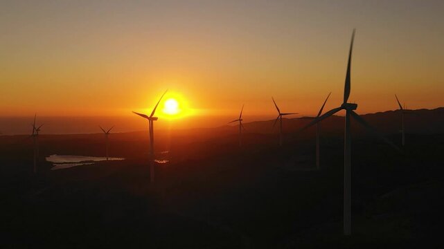 Aerial view of Wind generators turbines and wind farm mills at sunset. Wind power plant. Philippines.