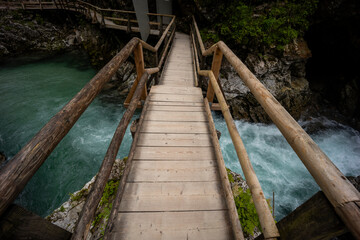 Vintgar Gorges Park a few km from Lake Bled, Slovenia. Wooden walkways accompany the path above the river rapids and waterfalls. River hits rocks and creates fog.Adventure family holidays. Freshness.