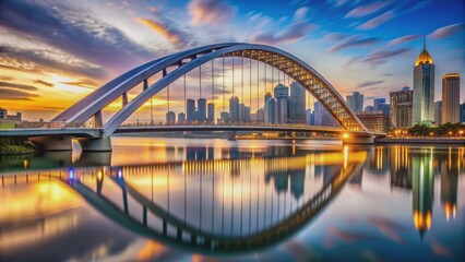 Obraz premium Sleek arched modern bridge stretches majestically over serene waters, perfectly framing vibrant city skyline with gleaming skyscrapers at twilight hour.