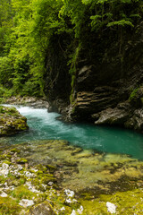 Vintgar Gorges Park a few km from Lake Bled, Slovenia. Wooden walkways accompany the path above the river rapids and waterfalls. River hits rocks and creates fog.Adventure family holidays. Freshness.