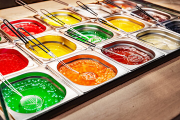 Confectionery display case with jelly substance in metal trays. sweet shop, street food, colorful...