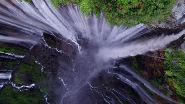 Aerial view of lush jungle with Tumpak Sewu waterfall and Semeru volcano, East Java, Indonesia.