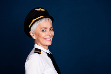 Photo portrait of pretty retired female professional airline pilot toothy smile wear aviator uniform isolated on dark blue color background