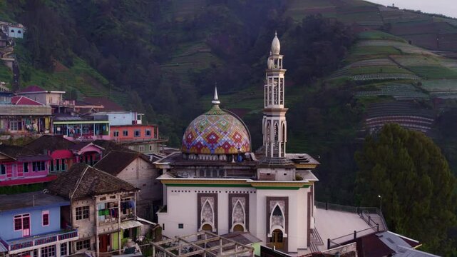 Aerial view of colorful village with mosque and terrace farming at Mount Sumbing, Magelang City, Central Java, Indonesia.