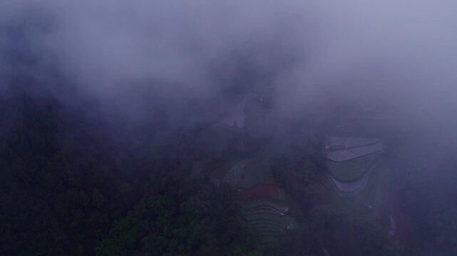 Aerial view of foggy mountain landscape with clouds and mosque at sunrise, Magelang City, Central Java, Indonesia.
