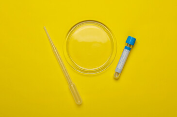 Petri dish with pipette, test tube on a yellow background. Top view