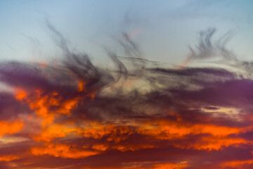 Burning clouds in the sky at sunset