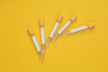 Medical empty blood tubes on yellow background