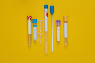 Various Empty Medical Laboratory Test Tubes on Yellow Background