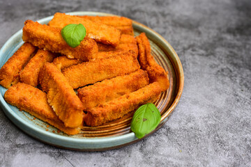Close up of   Crispy breaded  deep fried fish fingers with breadcrumbs served  with remoulade sauce and  lemon Cod Fish Nuggets on rustic wood table background