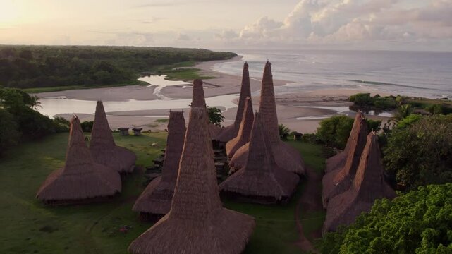 Aerial view of traditional village with thatched roofs, coast, ocean, and beach, Ratenggaro, Sumba, Indonesia.
