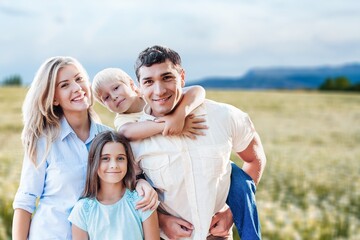 Obraz premium Happy young family and children on morning walk