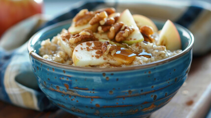 Bowl of oatmeal with apple slices, walnuts, honey, and cinnamon in a patterned blue ceramic bowl