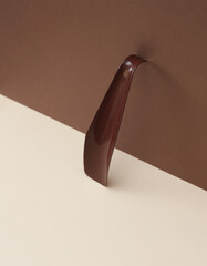 Shoe horn on beige brown background