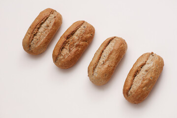 Appetizing rye buns on a beige background