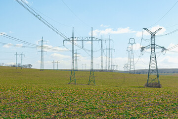 High voltage distribution poles with cables in the countryside