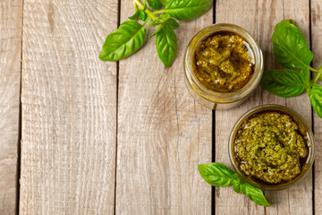 Pesto. Italian basil pesto sauce on a textured wooden background. Ingredient for pesto sauce: fresh...