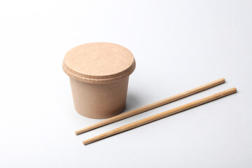 Craft take-away take-out food paper container, cardboard round disposable packaging box with Chinese chopsticks.on white background