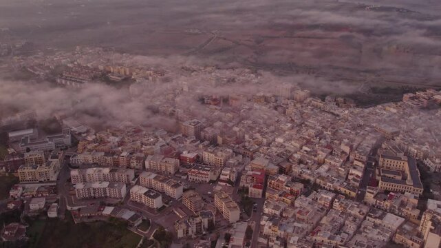 Aerial view of medieval city at sunrise with clouds, Ginosa, Italy.