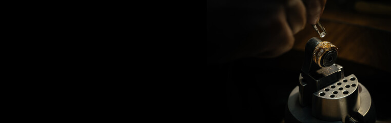 Jeweler puts diamond to golden wedding luxury ring.