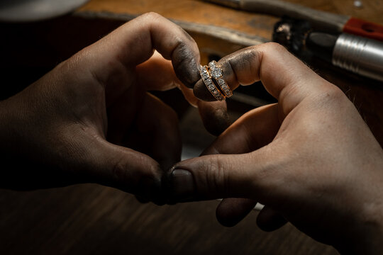 craftsman making diamond ring. hand made jewelery. Put diamond gem ring. diamond ring production. hand made in craftsman workshop close up. black background.