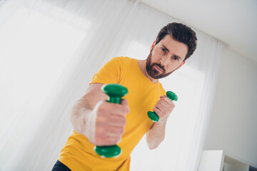 Photo of athletic strong bearded man practicing physical exercises gym indoors house home