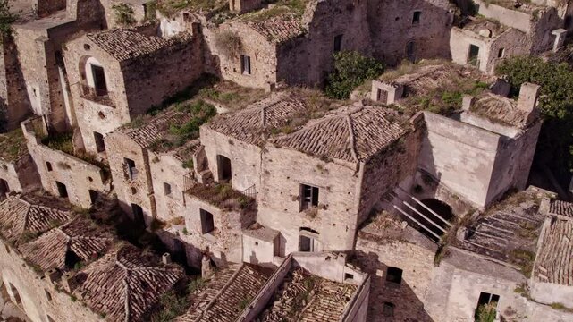 Aerial view of abandoned medieval town with ruins and church on hill, Craco, Basilicata, Italy.