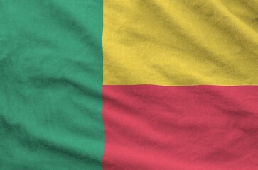 Benin flag depicted on folded wavy fabric of old cloth close up