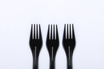 Black plastic forks on a white background