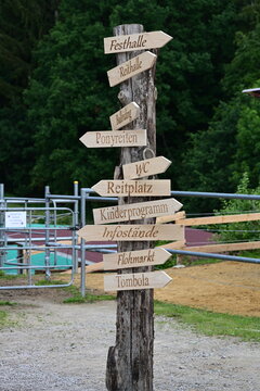 Pferdefest. H&ouml;lzernes Hinweisschild auf Reiterhof beim Hoffest