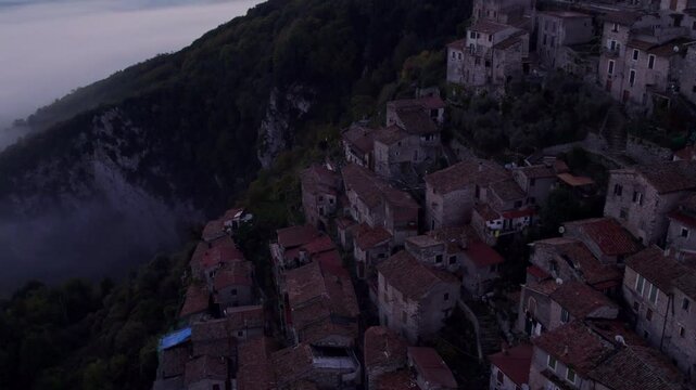 Aerial view of Santo Stefano church in sunrise with fog and clouds over medieval town, Artena, Italy.