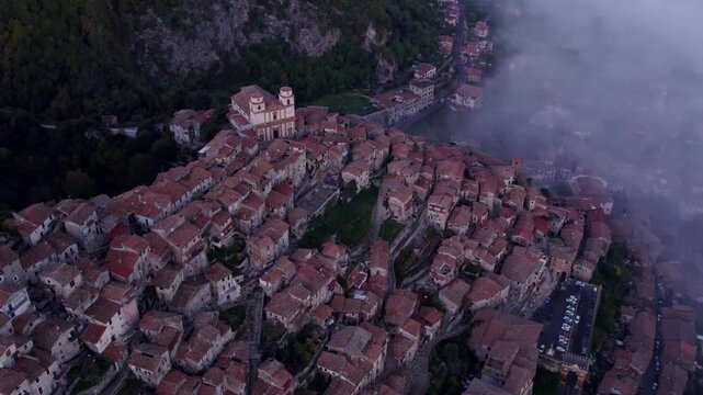 Aerial view of foggy sunrise over Santo Stefano church in medieval town, Artena, Italy.