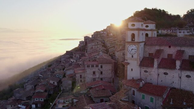 Aerial view of Santo Stefano church at sunrise with fog and mountain in Artena, Rome, Italy.