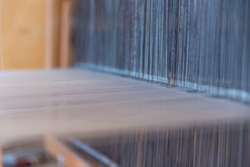 Weaving, traditional crafts,Close-up of a loom weaving, Woven silk,using cotton and silk string stretch and woven by using mechanic wooden machine to weave,