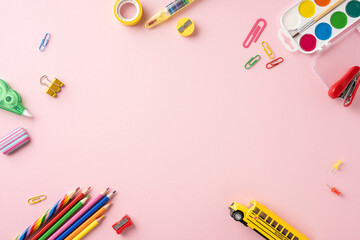 Top view of various school stationery supplies on a pink background. Perfect image for back to school themes and educational concepts