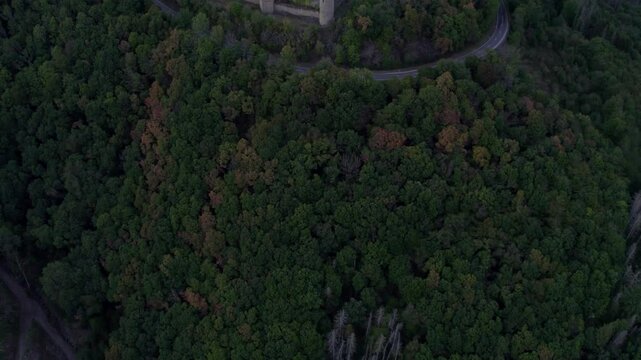 Aerial view of medieval castle surrounded by autumn trees and hills, Bourscheid, Luxembourg.