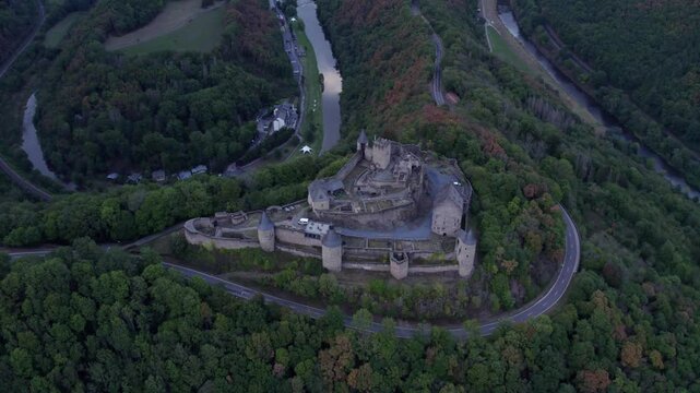 Aerial view of medieval castle surrounded by autumn trees and hills, Bourscheid, Luxembourg.