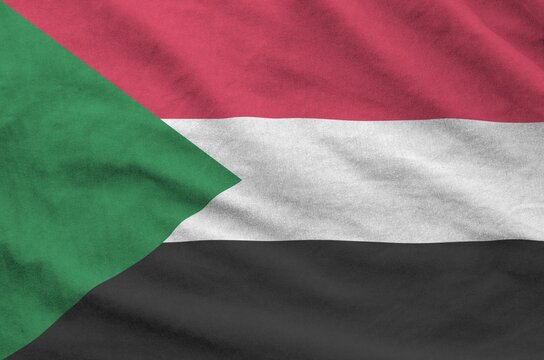 Sudan flag depicted on folded wavy fabric of old cloth close up
