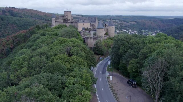 Aerial view of medieval castle surrounded by autumn trees and hills, Bourscheid, Luxembourg.