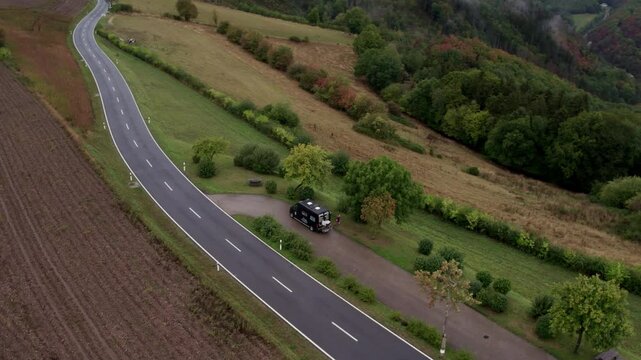 Aerial view of moody road and countryside with camper, Bourscheid, Luxembourg.