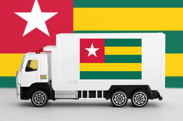 Togo flag depicted on side wall of white delivery van close up. Shipping and local delivery concept