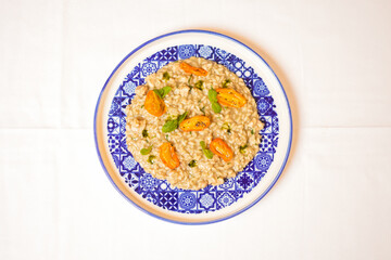 Risotto mantecato con burro e asparagi, guarnito con pomodori gialli arrostiti servito in un ristorante elegante