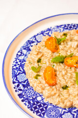 Risotto mantecato con burro e asparagi, guarnito con pomodori gialli arrostiti servito in un ristorante elegante