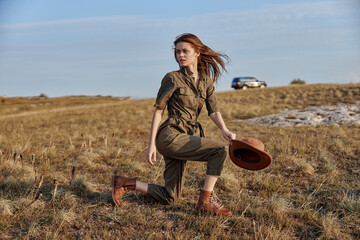 Woman in field with hat and car in background serene beauty of nature and travel adventure