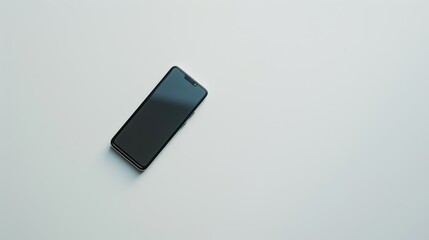 Modern smartphone is lying on a white table with a blank screen, perfect for showcasing an app or website