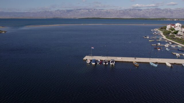 Aerial view of serene coastal town with mountains and blue water, Nin, Croatia.
