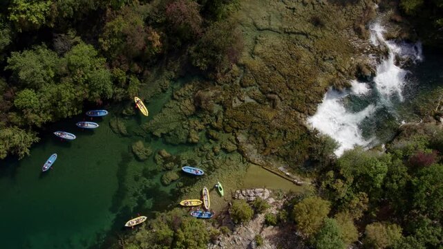 Aerial view of tranquil river with cascading waterfall and lush forest, Zrmanja, Croatia.