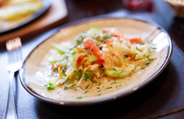Plate with fresh vegetable salad of tomato, cucumber and celery close up