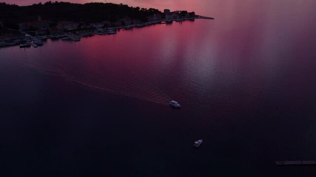 Aerial view of colourful boat cruising in serene sea at sunset, Krapanj, Sibenik, Croatia.