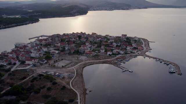 Aerial view of coastal town of Krapanj with island and boat during sunset, Sibenik, Croatia.